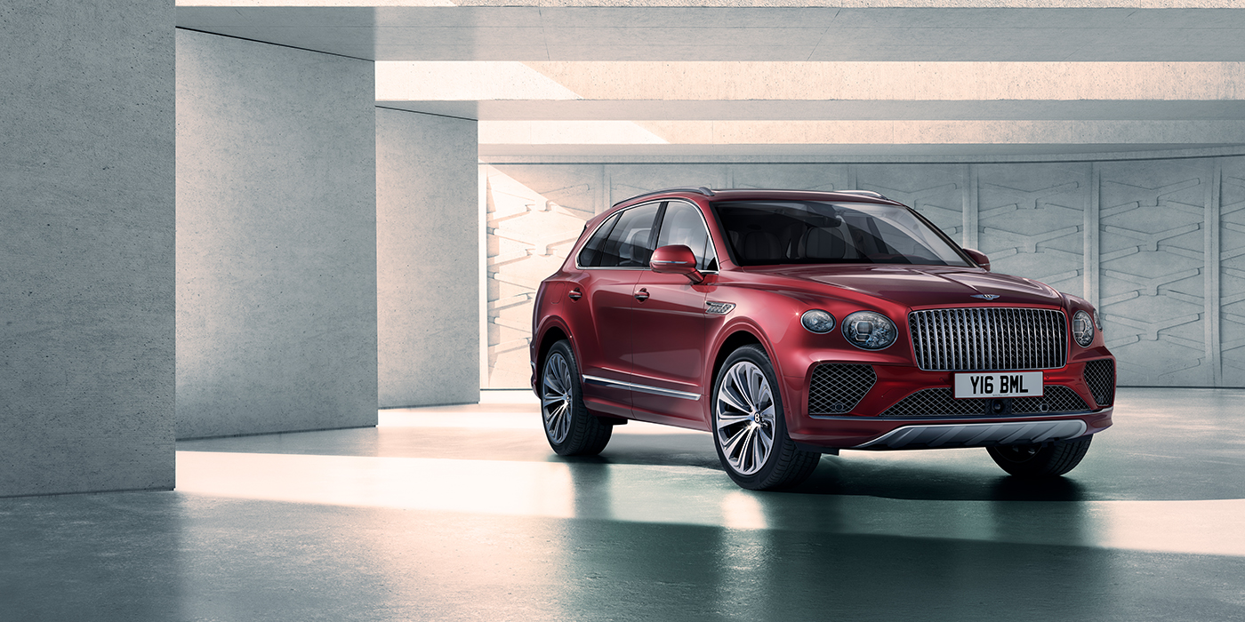 Bentley Edinburgh Bentley Bentayga Atelier Edition SUV in Rubino Red paint front three quarter against textured concrete wall