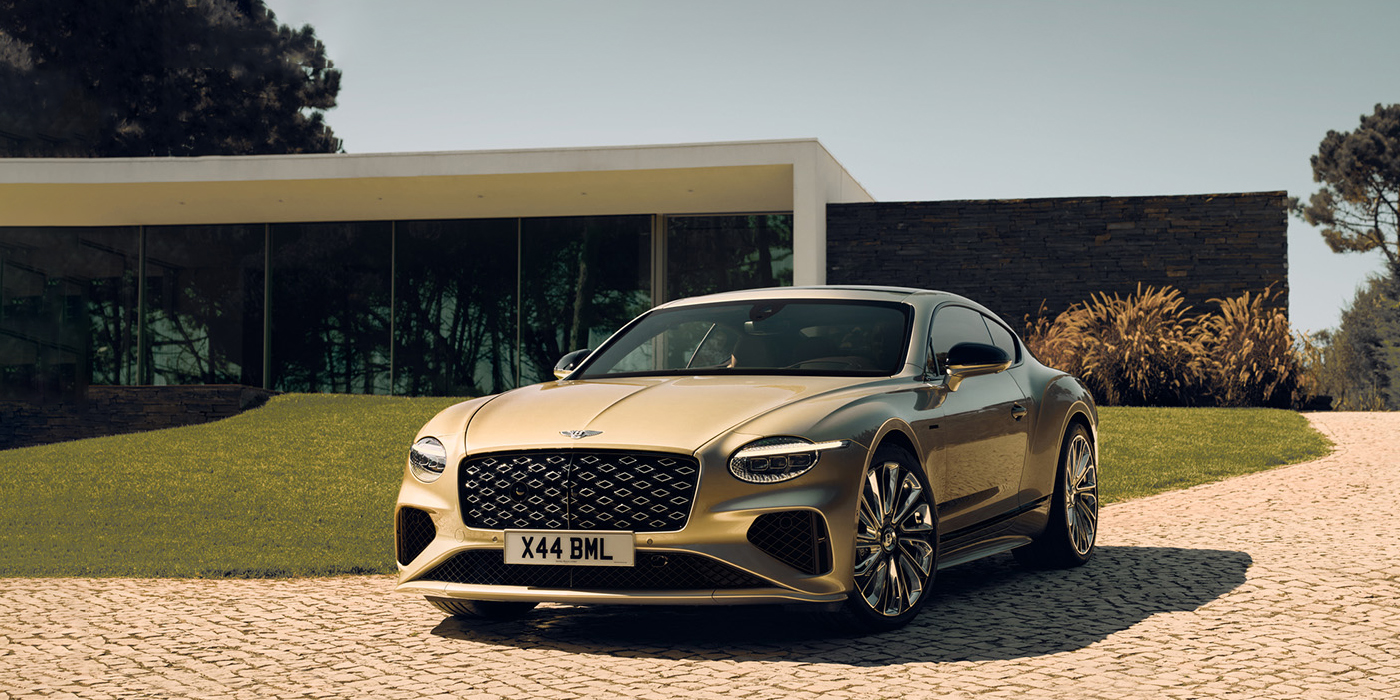 Bentley Edinburgh Bentley Continental GT Mulliner coupe front three quarters in Patina paint parked outside a glass fronted building with a grass lawn behind it