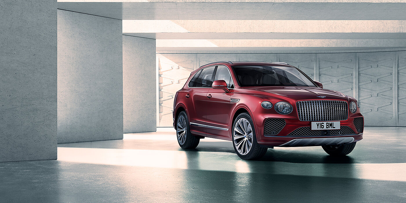 Bentley Edinburgh Bentley Bentayga Atelier Edition SUV in Rubino Red paint front three quarter against textured concrete wall
