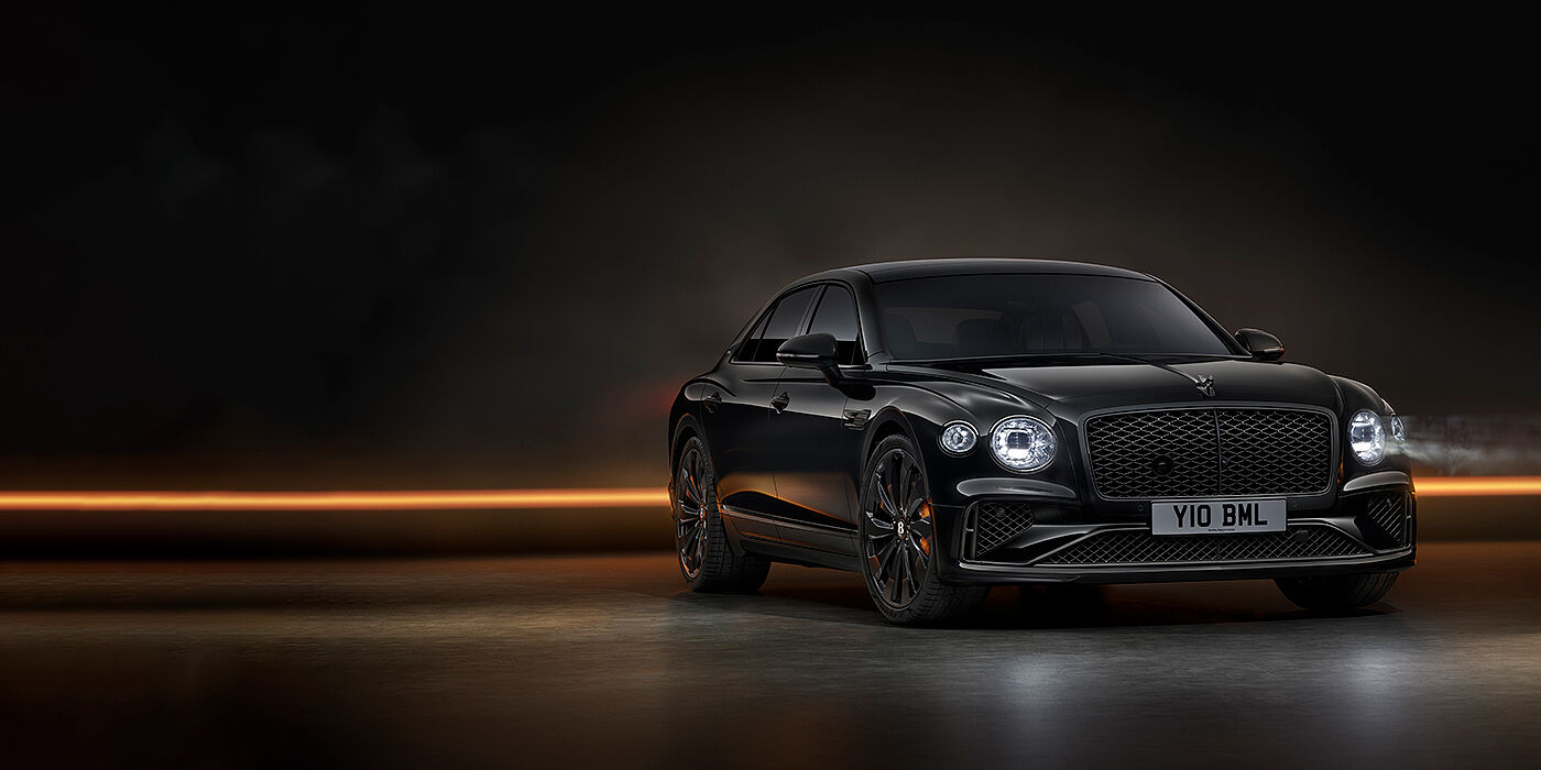 Bentley Edinburgh Bentley Flying Spur Black Edition sedan in Black Crystal paint against a dark grey and copper coloured background