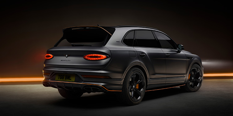 Bentley Edinburgh Bentley Bentayga S Black Edition SUV rear three quarter in Anthracite Satin paint against a dark red and yellow background