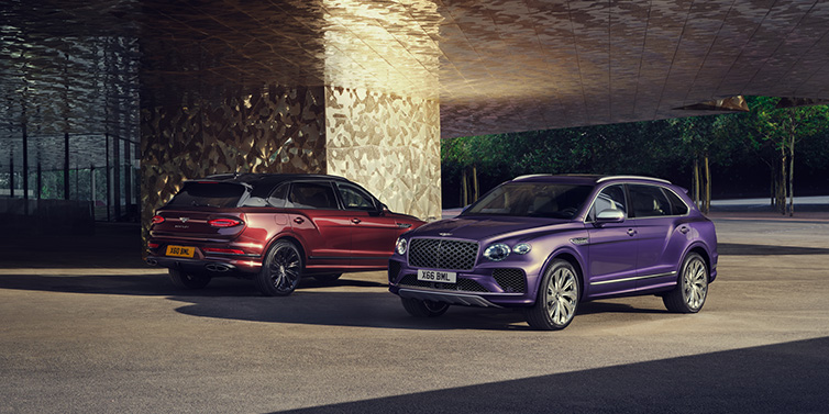 Bentley Edinburgh A duo of Bentley Bentayga Extended Wheelbase Mulliner SUVs parked in a city environment, with Tanzanite Purple and Cricket Ball red exterior paint