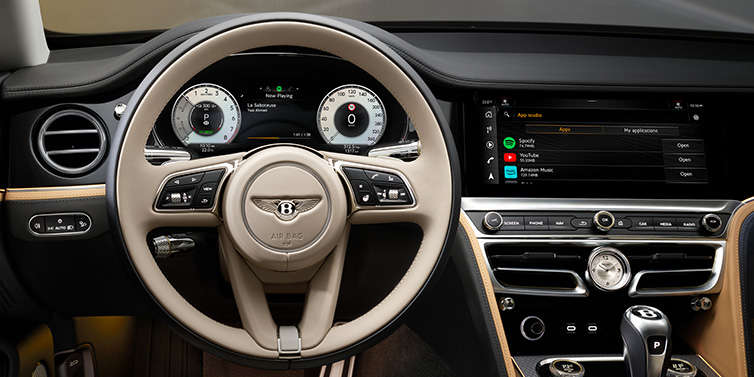 Bentley Edinburgh Bentley Flying Spur Mulliner sedan front interior detail of steering wheel and driver screens surrounded by Linen and Beluga black hides